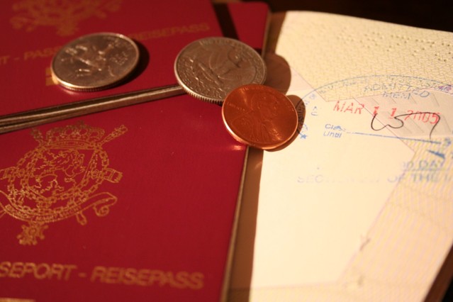 Pár mincí ležících na cestovních pasech